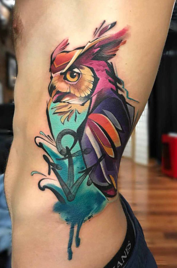 Colourful angry owl tattoo on ribs